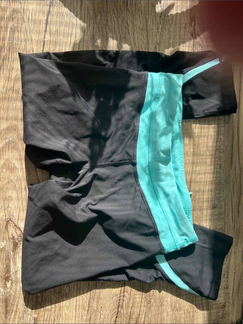 Lululemon Black Athletic 3/4 length tights with Teal Waistband and stripes.